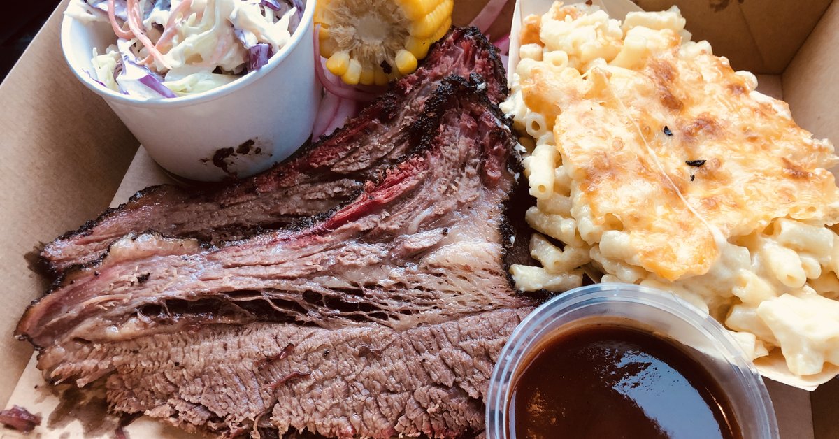 Texas BBQ brisket plate with cornbread and mac and cheese sides on a checkered tablecloth