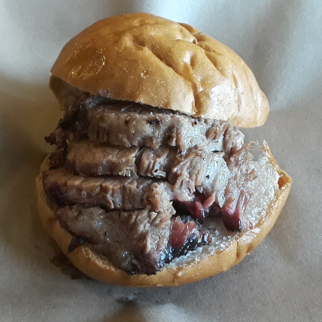 Texas BBQ brisket sandwich with sliced smoked meat piled high on a white bun