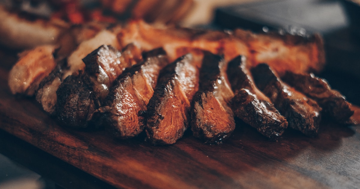 Perfectly smoked Texas BBQ brisket sliced on a wooden cutting board with smoke ring visible